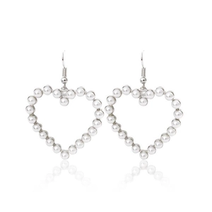 Detail of elegant heart-shaped earrings featuring white pearls and silver hooks