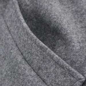 Detailed macro view of dark grey wool blend fabric texture for casual winter coat
