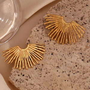 Detail of 18K gold-plated fan-shaped earrings on stone and champagne silk background