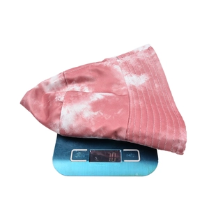 Chapeau bob tie-dye pesant 70g sur une balance montrant son tissu en coton léger et doux