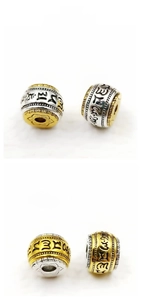 Macro detail of two-tone silver beads with mantra engraving and 12mm diameter size