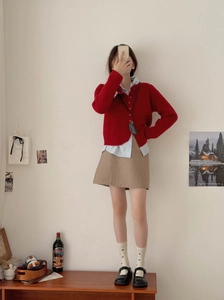 Close-up of red knit cardigan paired with white heart socks and Mary Jane shoes