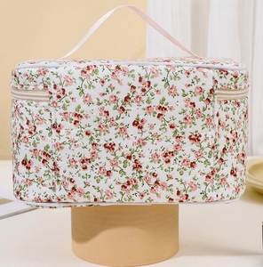 Detail of floral quilted makeup bag featuring pink flower pattern and soft fabric texture