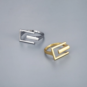Detailed view of silver and gold geometric rectangular open rings in minimalist style