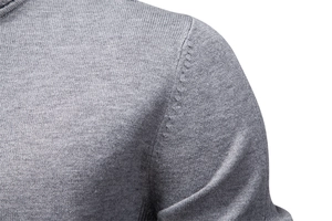 Macro shot of grey knit sweater shoulder seam detailing showing fine stitching quality