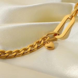 Gold 18K plated Cuban chain bracelet with heart pendant on white silk fabric