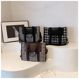 Detail of vintage houndstooth tote bags with PU leather handles in black and brown