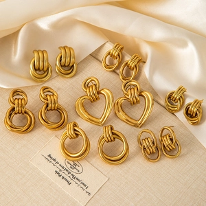 Flat lay of diverse gold-plated hoop and heart earrings on elegant silk fabric
