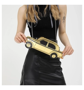 Detail of creative gold mirror taxi shaped crossbody bag with silver chain strap on model