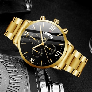Macro detail of men's gold watch with black dial, Roman numerals and triple sub-dials
