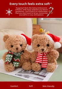 Close-up of two brown teddy bears with Christmas hats and scarves on a magazine