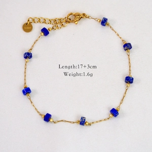 Detail of 14k gold stainless steel bracelet with blue beads and S.Steel logo tag