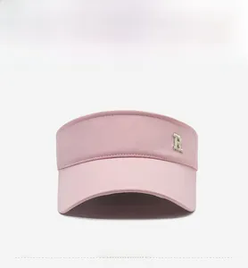 Front view of pink sun visor hat with a metal R letter detail and wide brim