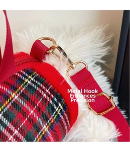 Close-up of golden metal hooks and red tartan fabric on a plush dog crossbody bag