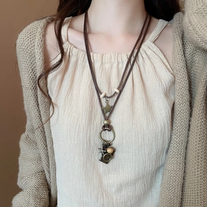 Close-up of retro necklace with butterfly pendant and wood beads on linen clothes