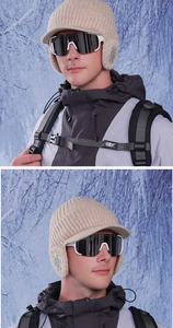 Detail of winter knit baseball cap with ear flaps and snowflake pattern in snow