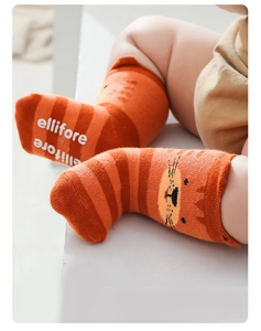 Detailed macro view of non-slip silicone grippers on orange striped baby socks