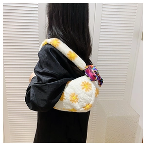 Plush shoulder bag with yellow daisy pattern and colorful silk scarf on a model