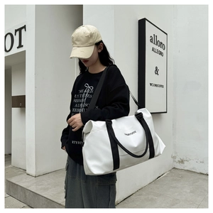 Macro detail of white oxford fabric travel bag featuring durable handles and shoulder strap