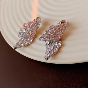 Luxury marquise cut zircon wing earrings in silver finish on white ceramic tray