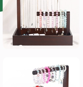 Detail of dark wood jewelry display stand with multi-layer hooks and bracelet bars