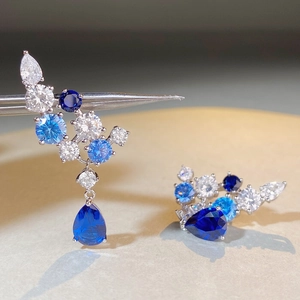 Blaue Saphir-Ohrhänger in Tropfenform mit Silberfassung und funkelnden Kristallen