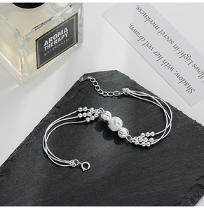 Detailed close-up of S925 sterling silver multi-layer beaded bracelet on a black slate
