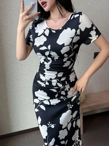 Detail eines schmal geschnittenen Kleid mit schwarz-weißem Blumendruck und Raffungen