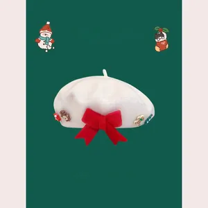 Close-up of a white wool beret featuring a festive red bow and 3D Christmas charms