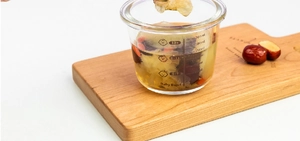 Detail of 200ml glass baby food bowl featuring measurement scales and age-based markings
