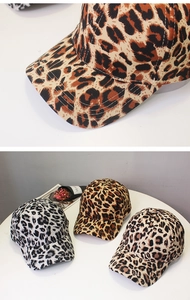 Detailed view of leopard print baseball caps showing fabric texture and vibrant colors