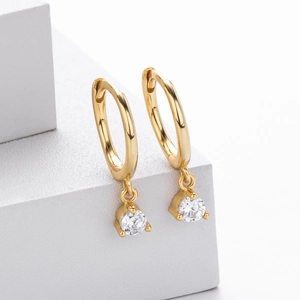 Detail view of 925 sterling silver gold earrings with round zircon stones on stone