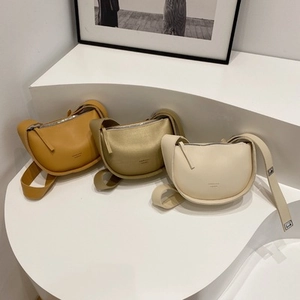 Tres elegantes bolsos tipo montura en tonos amarillo, oro y beige con correas anchas