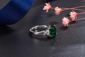Detailed view of S925 silver ring with pear-cut green emerald and marquise zircon accents