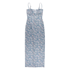 Détail d'une robe longue bleue à imprimé fleuri avec fines bretelles et décolleté plissé