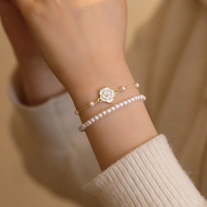 Elegant gold-plated camellia flower and pearl double-layer bracelet worn on hand