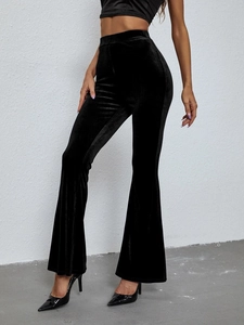 Detailed shot of high-waisted black velvet flare pants with elegant glossy texture