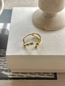 Detailed shot of a gold irregular organic bead ring on a textured white jewelry box