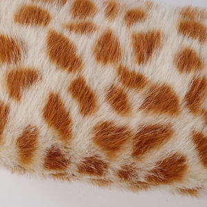 Macro shot of fluffy giraffe pattern plush fabric texture on a soft cosmetic bag