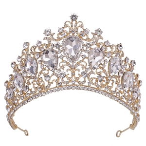 Detail of golden Baroque wedding tiara featuring red crystals and intricate scroll patterns