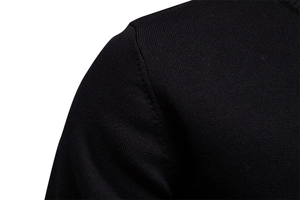 Détail de la couture d'épaule et de la texture en maille fine d'un pull noir en coton pour homme