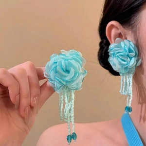 Detail of light blue fabric flower earrings with long beaded tassels and water drop beads