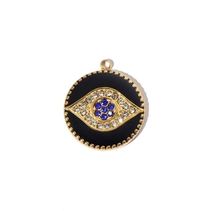 Macro view of golden evil eye pendant with blue zircon inlay and black enamel details