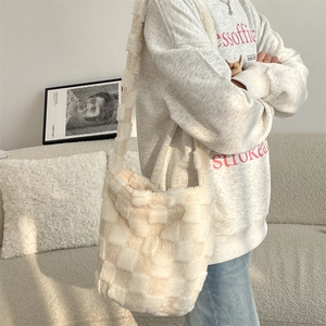Close-up of cream plush tote bag with checkered texture and wide shoulder strap
