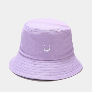 Détail d'un bob en coton lilas avec broderie smiley blanche et bordure à coutures multiples
