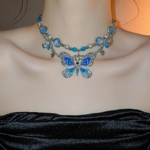 Vue détaillée d'un collier papillon avec cristaux bleus et perles porté par un mannequin