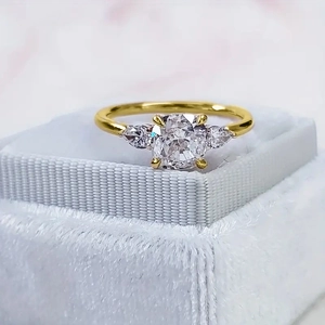 Elegante goudvergulde ring met kussengeslepen zirkoon en peervormige zijstenen