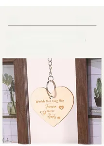 Close-up of wooden heart charm with pet memorial paw prints and hanging metal chain