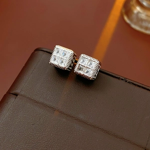 Gros plan de boucles d'oreilles carrées en argent avec quatre zircons sur cuir