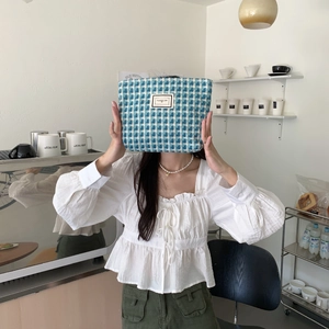 Détail de la pochette en tweed à carreaux bleus et blancs avec étiquette Pleasant Time